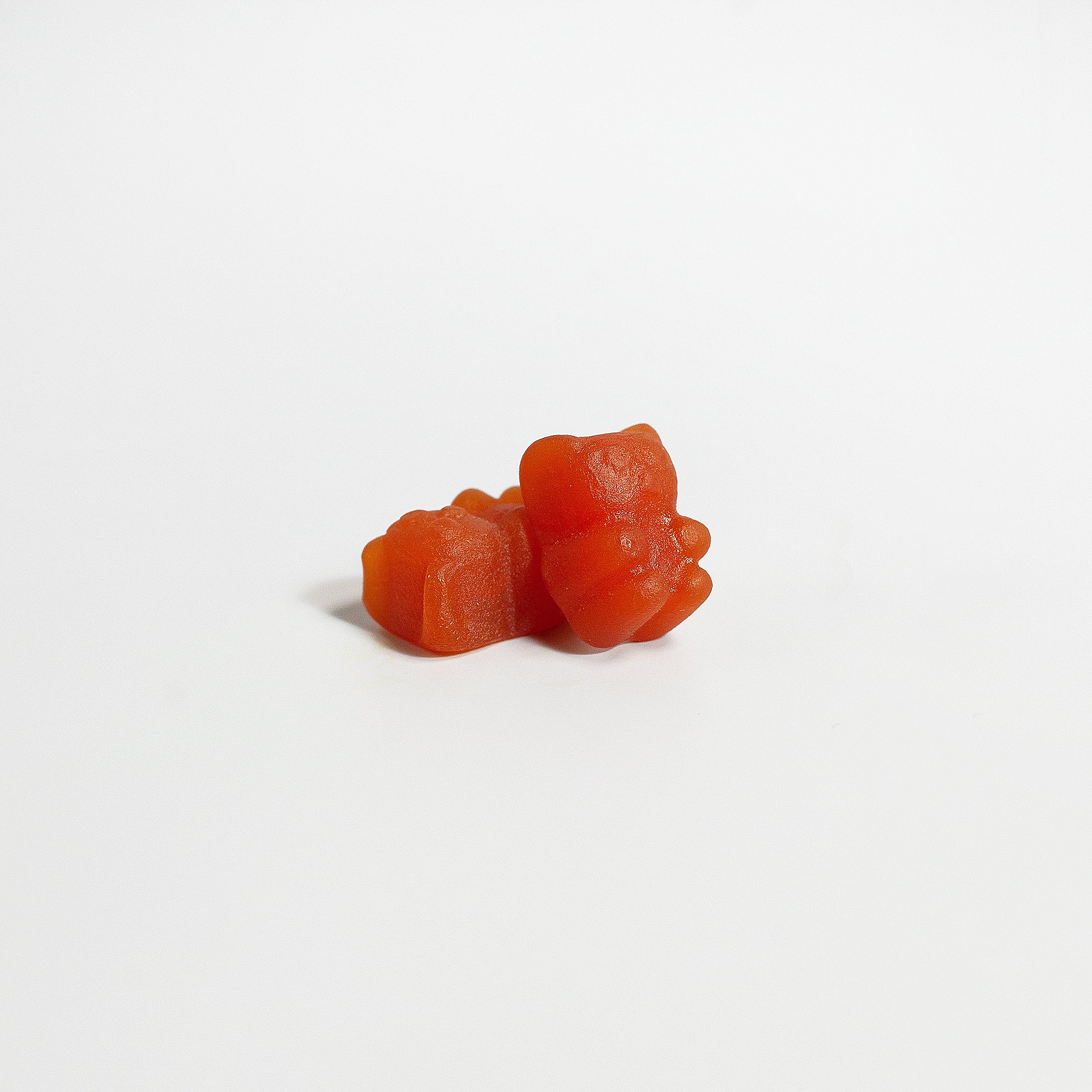Two orange gummy bears on a white background