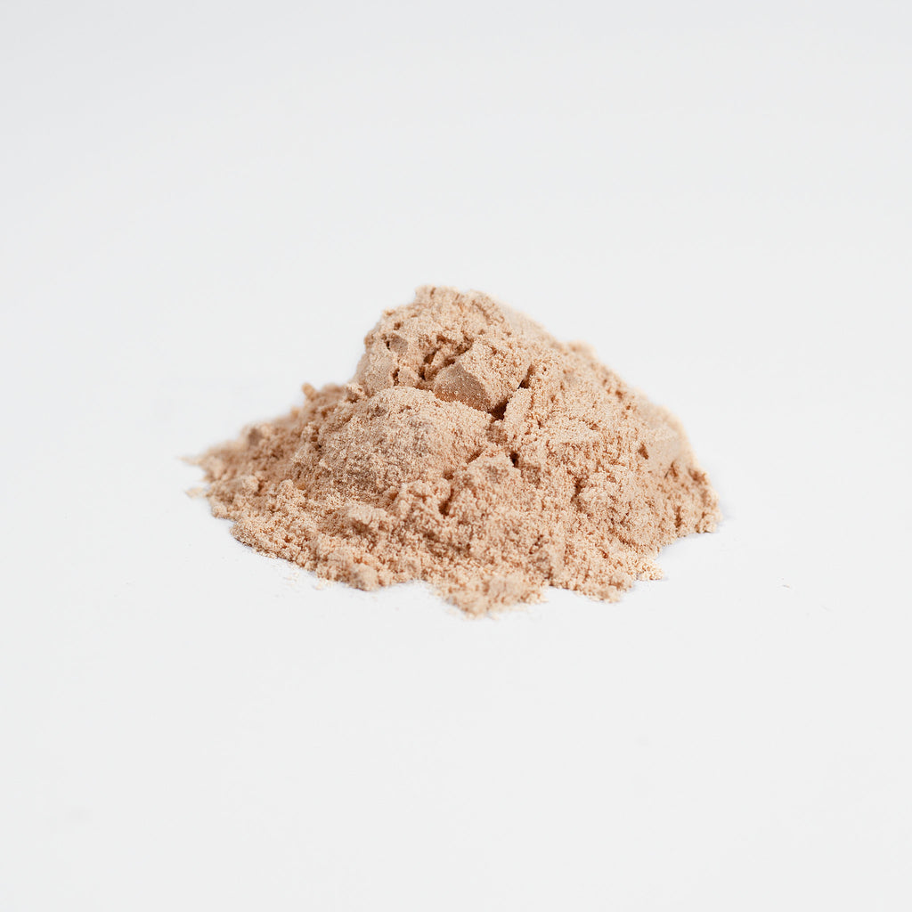 Two mounds of beige powder on a light gray background